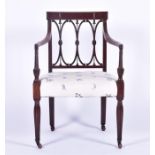 A Sheraton revival carved mahogany armchair with triple stick back designed as linked hoops, centred