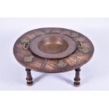 An early 20th century brass and copper mounted table of circular form, inset to the centre with a