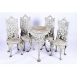 A set of four Victorian heavy cast iron garden chairs together with a later similar matched table,
