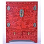 A Chinese cinnabar lacquered table cabinet decorated to the hinges and door handles with cloisonne