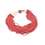 A multi-strand coral necklace comprising of forty strands of small beads, with woolen and button