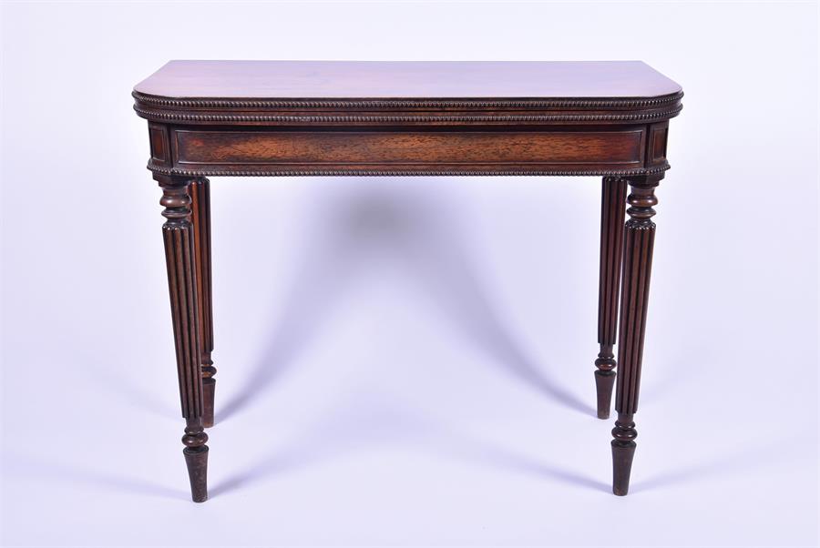 A Victorian rosewood fold-over card table with beaded borders in the Regency manner, opening to