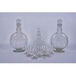 A pair of 20th century etched glass decanters of moon form together with another smaller and a set