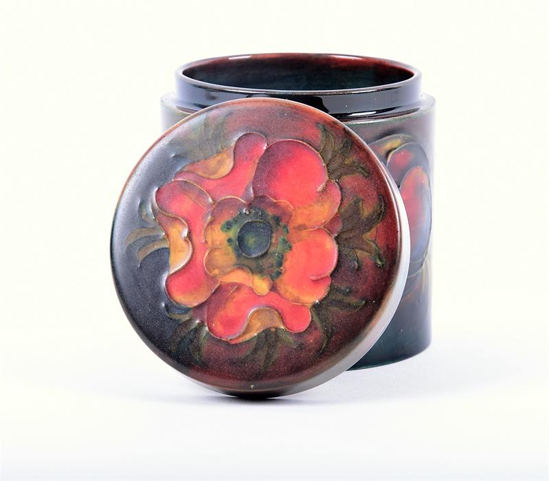 A Moorcroft porcelain lidded cylindrical storage jar the ground in subdued shades of blue and red, - Image 3 of 5