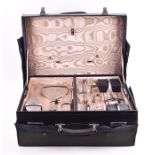 An Art Deco leather cased gentleman’s travelling vanity set with original canvas cover, initialed ‘