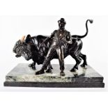 A large 19th / early 20th century bronze study of a figure toiling with an enraged bull the bull