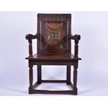 An 18th century English wainscot oak chair with carved back rest made from a church coffer with