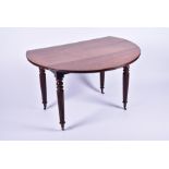 A Victorian mahogany drop leaf circular table on turned and fluted legs, terminating on brass