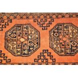 A red ground Afghan wool carpet and one other the fringed Afghan example decorated with geometric