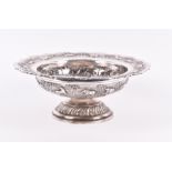 An Indian white metal pedestal bowl the circular bowl embossed with various animals on landscape