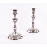 A pair of unmarked white metal candlesticks probably French, each with reeded central knopped