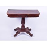 A 19th century rosewood fold over card table in the Regency style, with shaped column on a