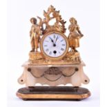 A late 19th century alabaster and gilt metal mantel clock with figural surmount beside a drum