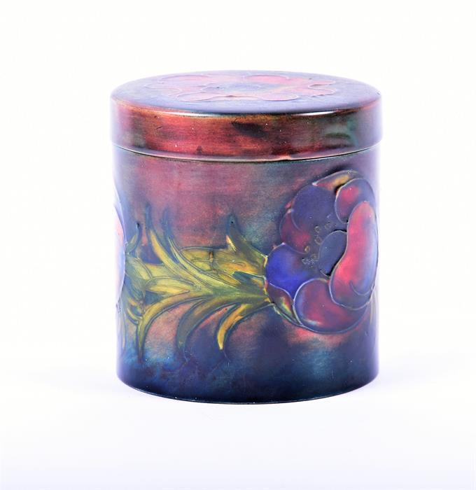 A Moorcroft porcelain lidded cylindrical storage jar the ground in subdued shades of blue and red, - Image 2 of 5