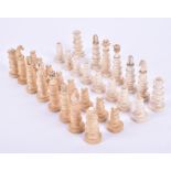 An unusual turned ivory European chess set one side a very faded buff colour, one white knight