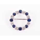 A sapphire and diamond brooch of circular form, set with eight alternating round brilliant-cut