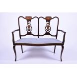 An Edwardian mahogany and inlaid two-seater salon sofa with pierced slat backs and upholstered