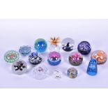 A collection of fourteen glass paperweights to include examples by Caithness Swarovski and Mdina,