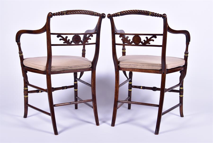 A pair of Regency style stained oak armchairs each with caned seats, applied brass collars and - Image 2 of 4