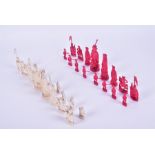 A late 19th century Chinese carved ivory chess set half stained red, 9.5 cm high maximum.