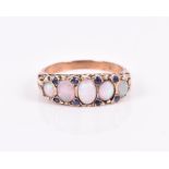A 9ct yellow gold, opal, and sapphire ring set with five graduated oval opals interspersed with