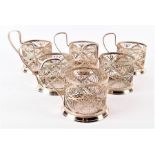 A set of six filigree white metal tea glass holders each with scrolling symmetrical decoration and