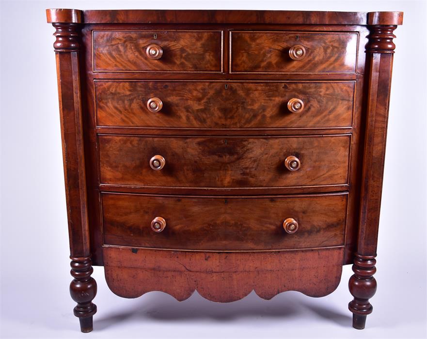 A large flame mahogany bow-front chest  with two short over three long drawers, flanked by faceted