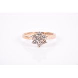 A 9ct yellow gold and diamond daisy cluster ring set with seven round-cut diamonds of