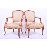 A pair of French Louis XV style fauteuils with upholstered backings, arm rests and seats, in