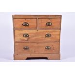 An early 20th century pine small chest with two short over two long drawers, the brass handles