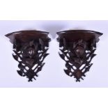 A pair of early 20th century European wooden wall brackets in the Heraldic style, with a shaped