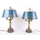 A pair of French Empire style bouillotte lamps with green and gilt tole shades, each holding three