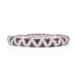 An 18ct white gold, and black and white diamond bangle pave-set to the upper half of the bangle with