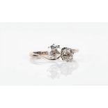 An 18ct white gold and diamond crossover ring set with two old round-cut diamonds of approximately