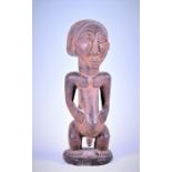 A central African carved hardwood Tribal figure, believed to originate from the Hemba people (