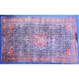 A small Persian rug the central field of detailed stylised foliate design with a repeating border on