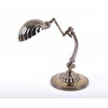 An early 20th century brass anglepoise desk lamp with shell shaped shade and articulated body,