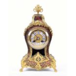 A late 19th century French Boulle mantel clock the tortoiseshell case inlaid with brass scrolls,