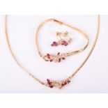 An 18ct yellow gold, diamond, and ruby suite of jewellery comprising a necklace, a bracelet, and a