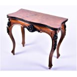 A Biedermeier style carved walnut card table the burr walnut veneered shaped top opening to reveal a