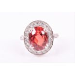 An unusual Songea sapphire and diamond ring set with an orange-red natural oval-cut sapphire of