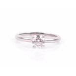 A platinum and solitaire diamond ring set with a round brilliant-cut diamond of approximately 0.80