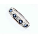 An 18ct white gold, diamond, and sapphire half eternity style ring set with five round brilliant-cut