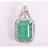 An impressive 18ct white gold, diamond, and emerald pendant set with an emerald-cut natural