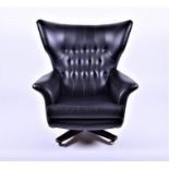 A G-Plan wing back swivel chair with button-back, upholstered in black leatherette, 89 cm wide.
