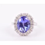 An 18ct white gold, diamond, and tanzanite cocktail ring set with an oval mixed-cut tanzanite of