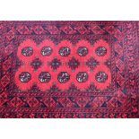 A small red ground Tekke rug  with a narrow rectangular central field featuring medallions within