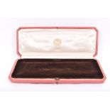 An early to mid 20th century Cartier jewellery box likely for a necklace, with cream silk