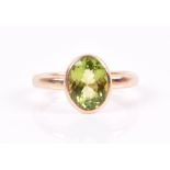 A 9ct yellow gold and peridot ring the mixed oval-cut peridot bezel-set, size Q 1/2, 5.5 grams