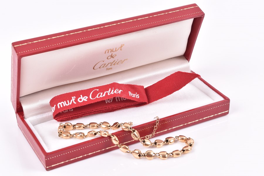 Cartier. An 18ct yellow gold and diamond bracelet with heart-shaped links, each set with three round